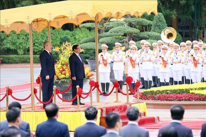 Thủ tướng Phạm Minh Chính và Thủ tướng Kyrgyzstan Adylbek Kasimalyev nghe quân nhạc cử Quốc thiều hai nước. Ảnh: TTXVN