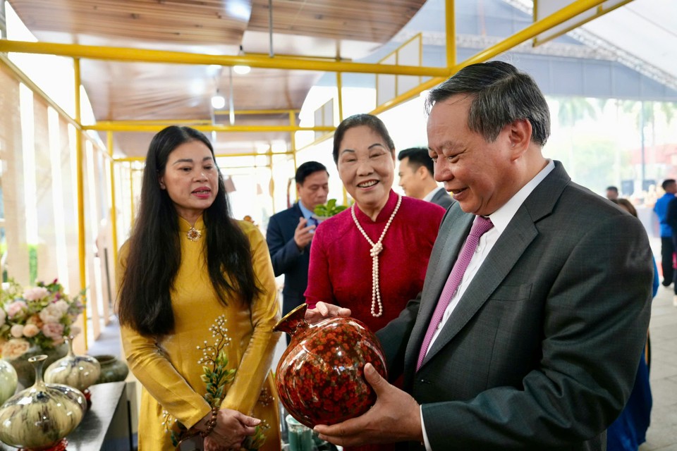 Giám đốc Sở VH&TT Hà Nội Bạch Liên Hương (áo vàng) cùng nghệ nhân Hà Thị Vinh giới thiệu đến Phó Bí thư Thường trực Thành ủy Hà Nội Nguyễn Văn Phong các sản phẩm làng nghề truyền thống. Ảnh: Duy Khánh.